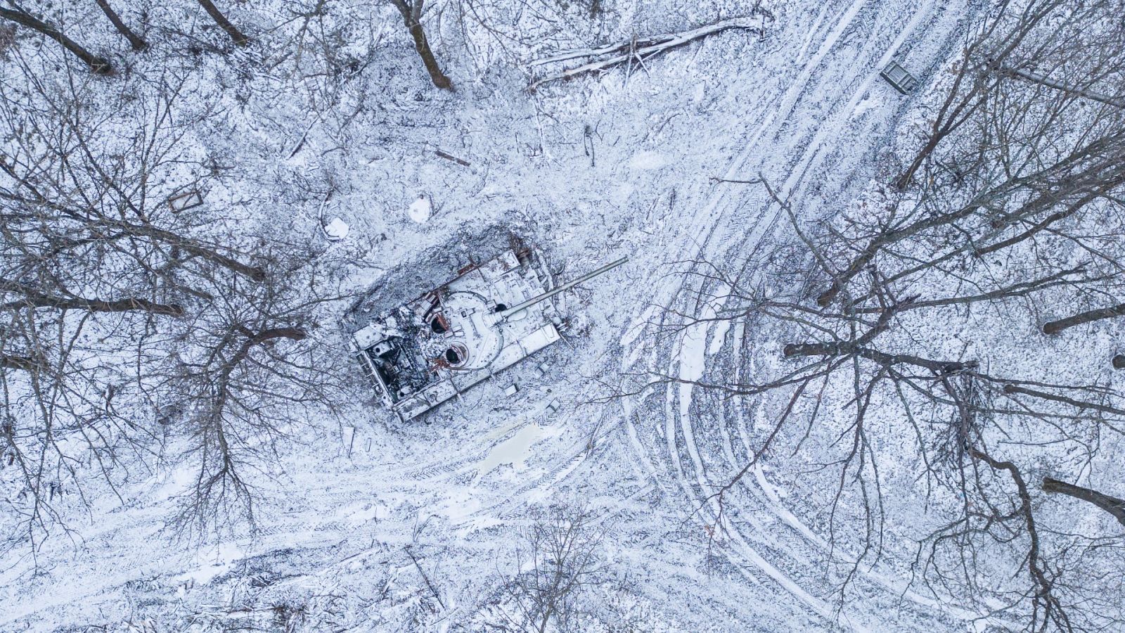Un tanque ruso destruido cubierto de nieve en un bosque en la región de Járkov