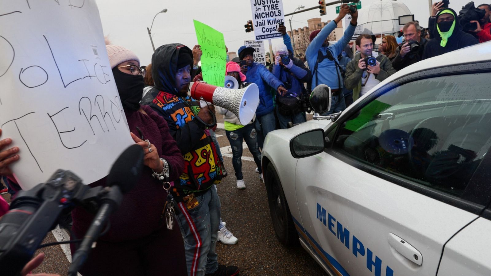 Gente protestando por la muerte de Tyre Nichols al lado de un coche de la Policía de Memphis.