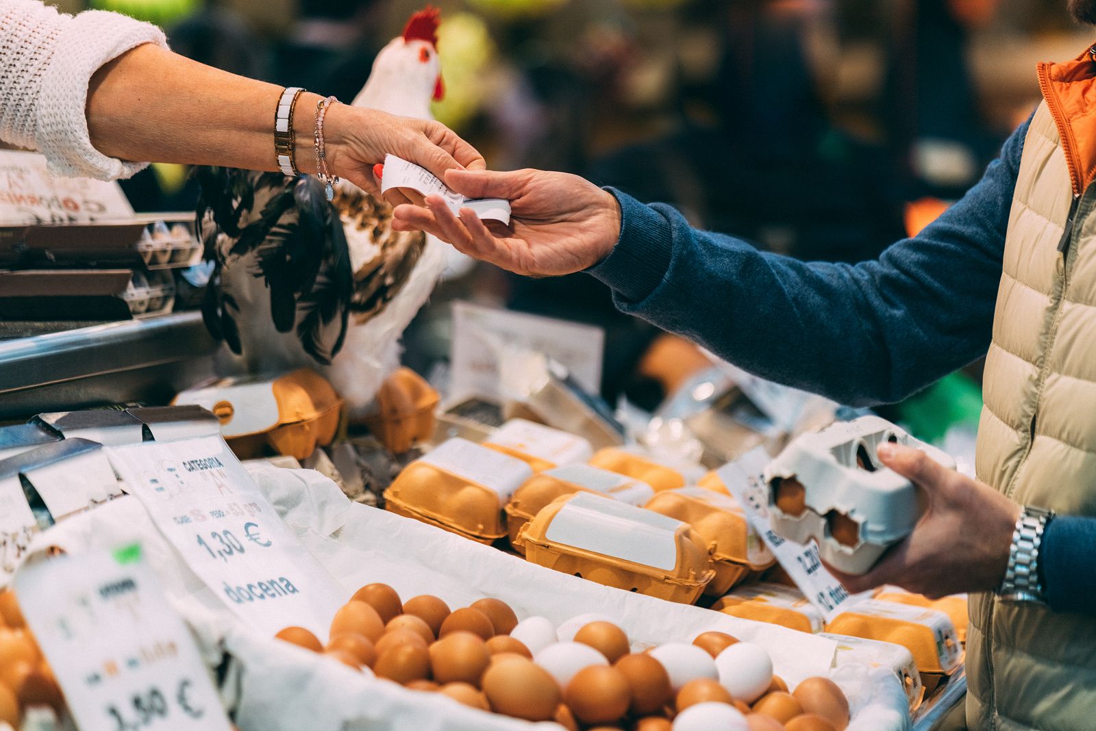 Una persona compra huevos en un mercado.