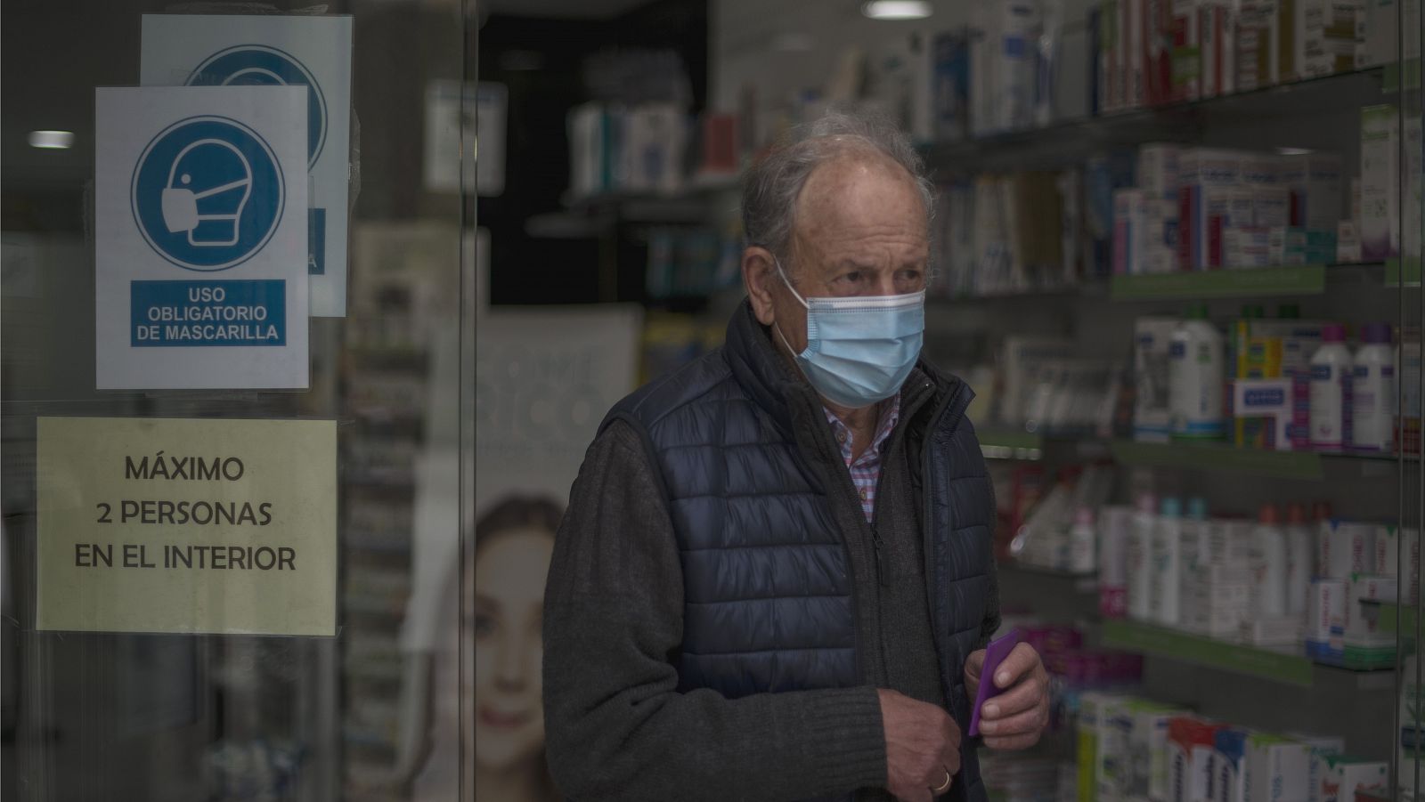 Un hombre sale de una farmacia con mascarilla en Ourense
