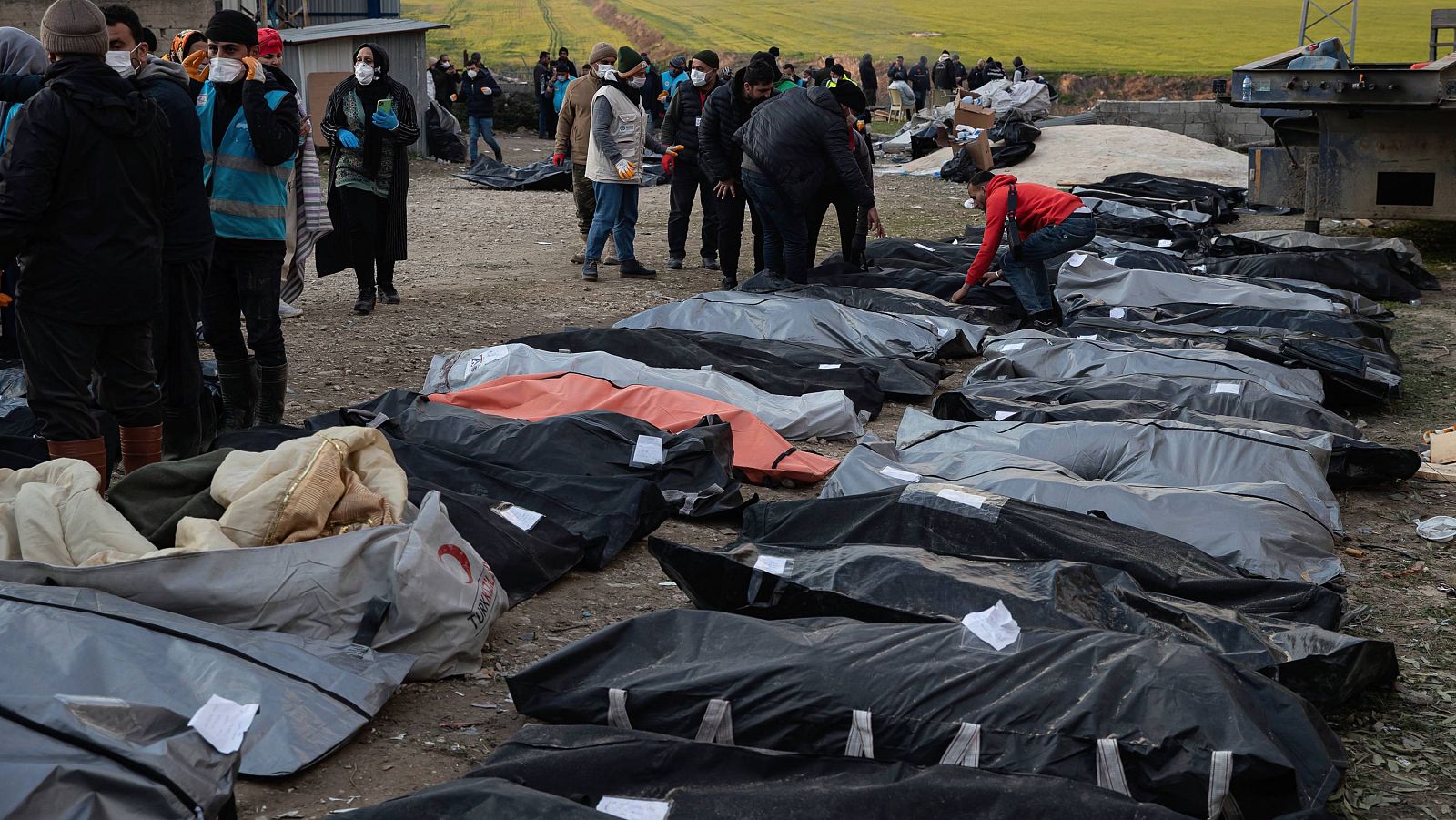 Varias personas junto a víctimas del terremoto en Hatay, en el sur de Turquía