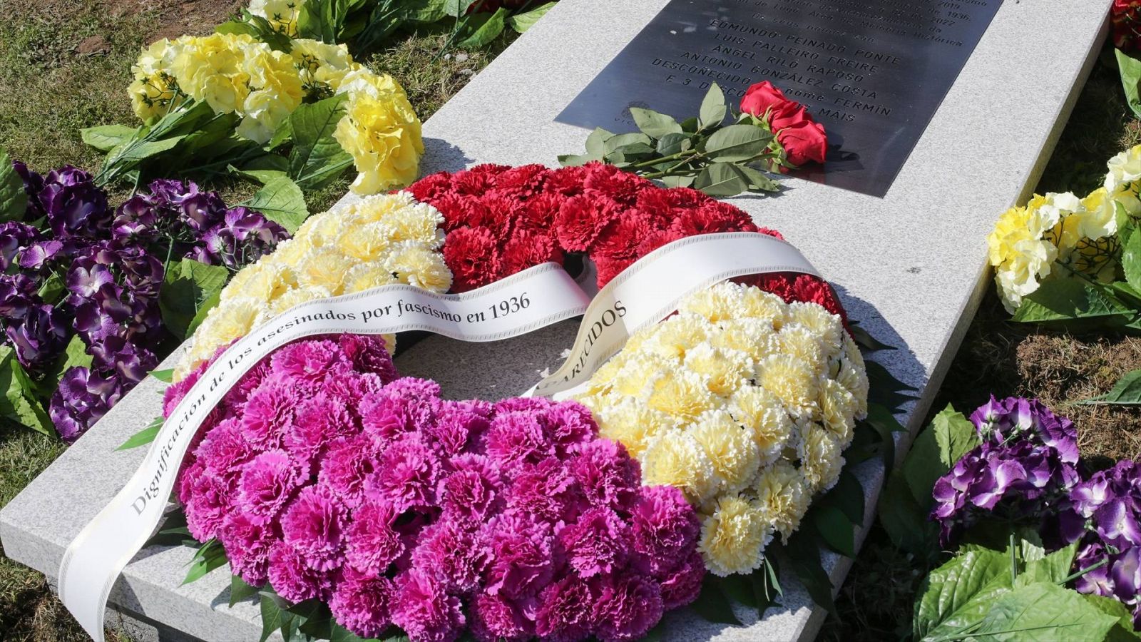 Detalle de los arreglos florales en una placa conmemorativa a las víctimas del franquismo en Lugo, Galicia