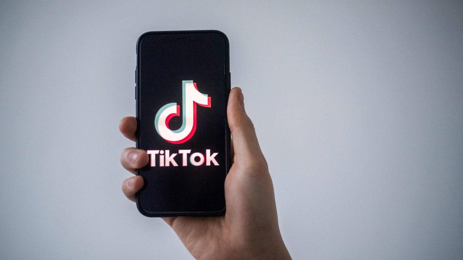 Un hombre muestra un teléfono con el logotipo de la red social china TikTok
