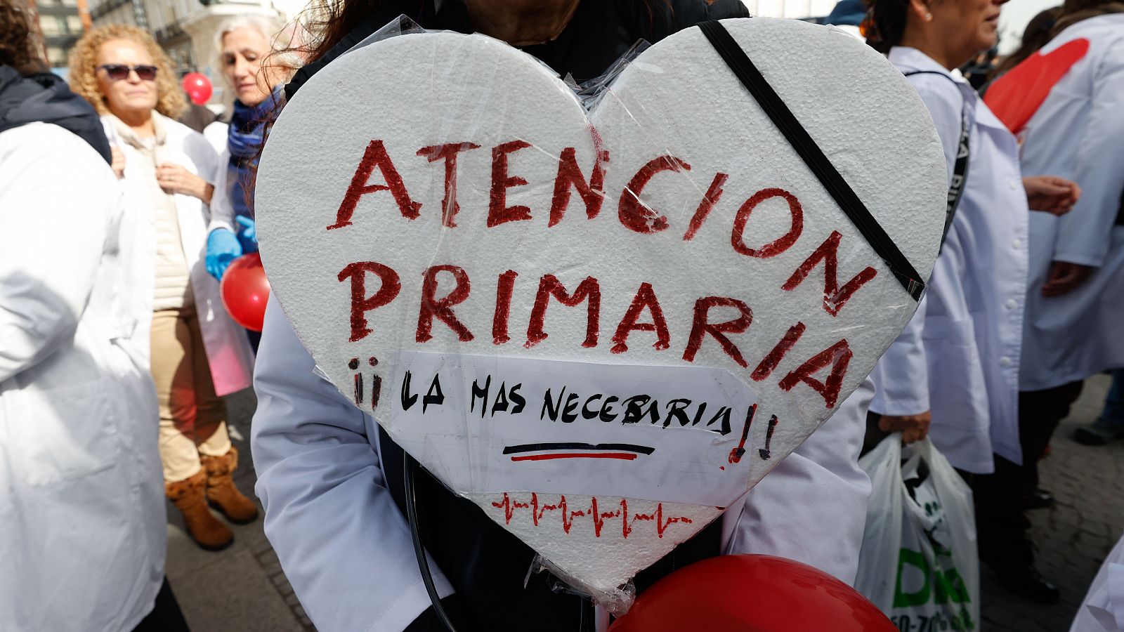 Vista de la manifestación de médicos y pediatras de la Atención Primaria. Una pancarta con forma de corazón dice "Atencion Primaria la mas necesaria"