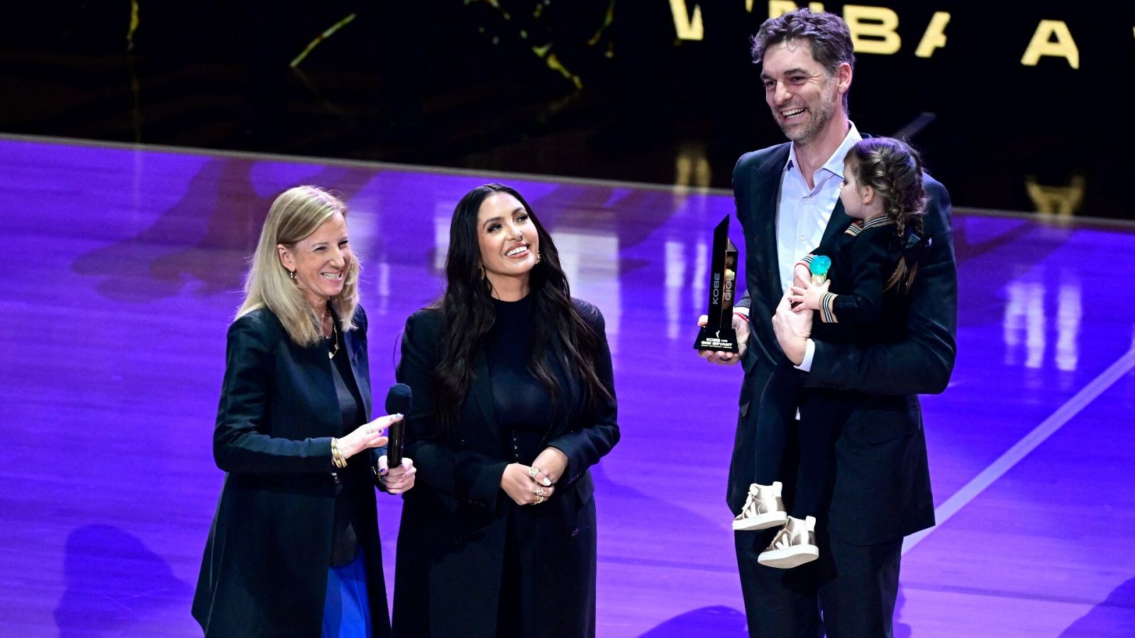Vanessa Bryant (c) recibe un premio de manos de Pau Gasol (d)