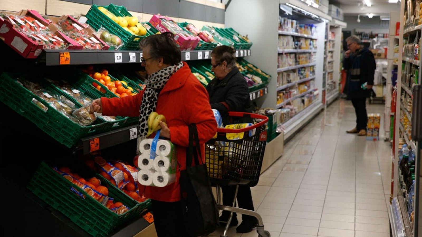 Varias personas hacen la compra en un supermercado en Madrid