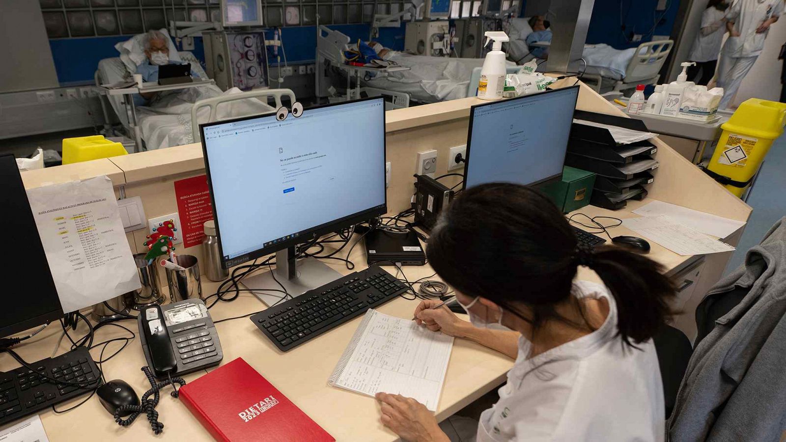 Una sanitaria del Hospital Clínic trabaja tomando notas a mano después del ciberataque.