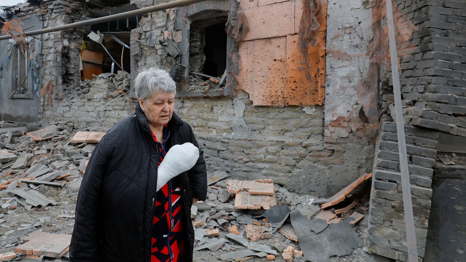Una mujer herida en un bombardeo enfrente de su casa destruida en Donetsk