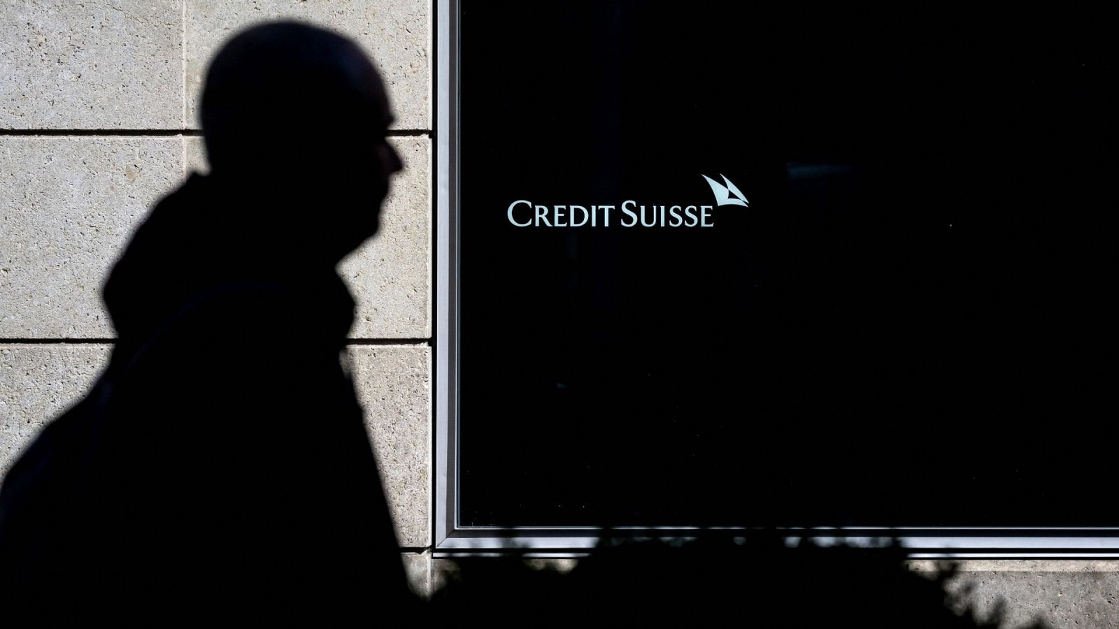 La silueta de un hombre que pasa por delante de una sucursal del banco Credit Suisse en Vevey, Suiza