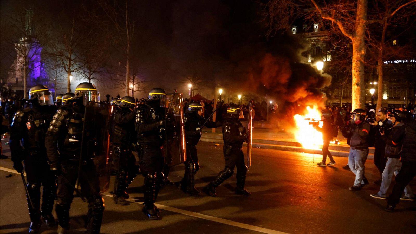 Varios agentes de la policía antidisturbios se enfrentan a manifestantes y periodistas durante una manifestación en París