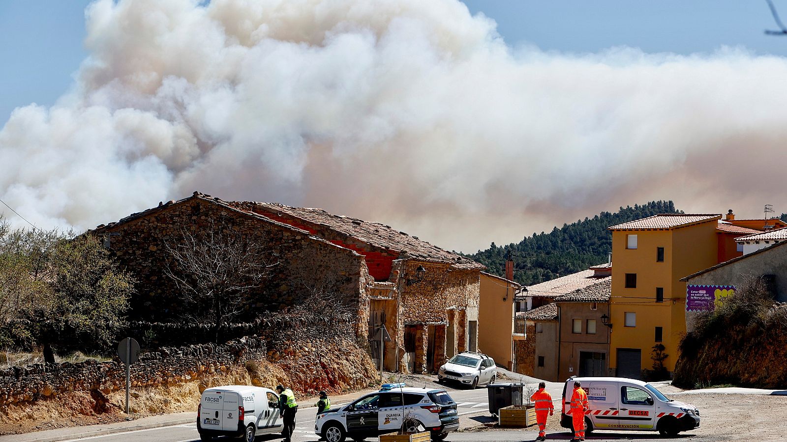 Guardia Civil y miembros de emergencias en la entrada a Villanuena de Viver en Castellón durante el incendio
