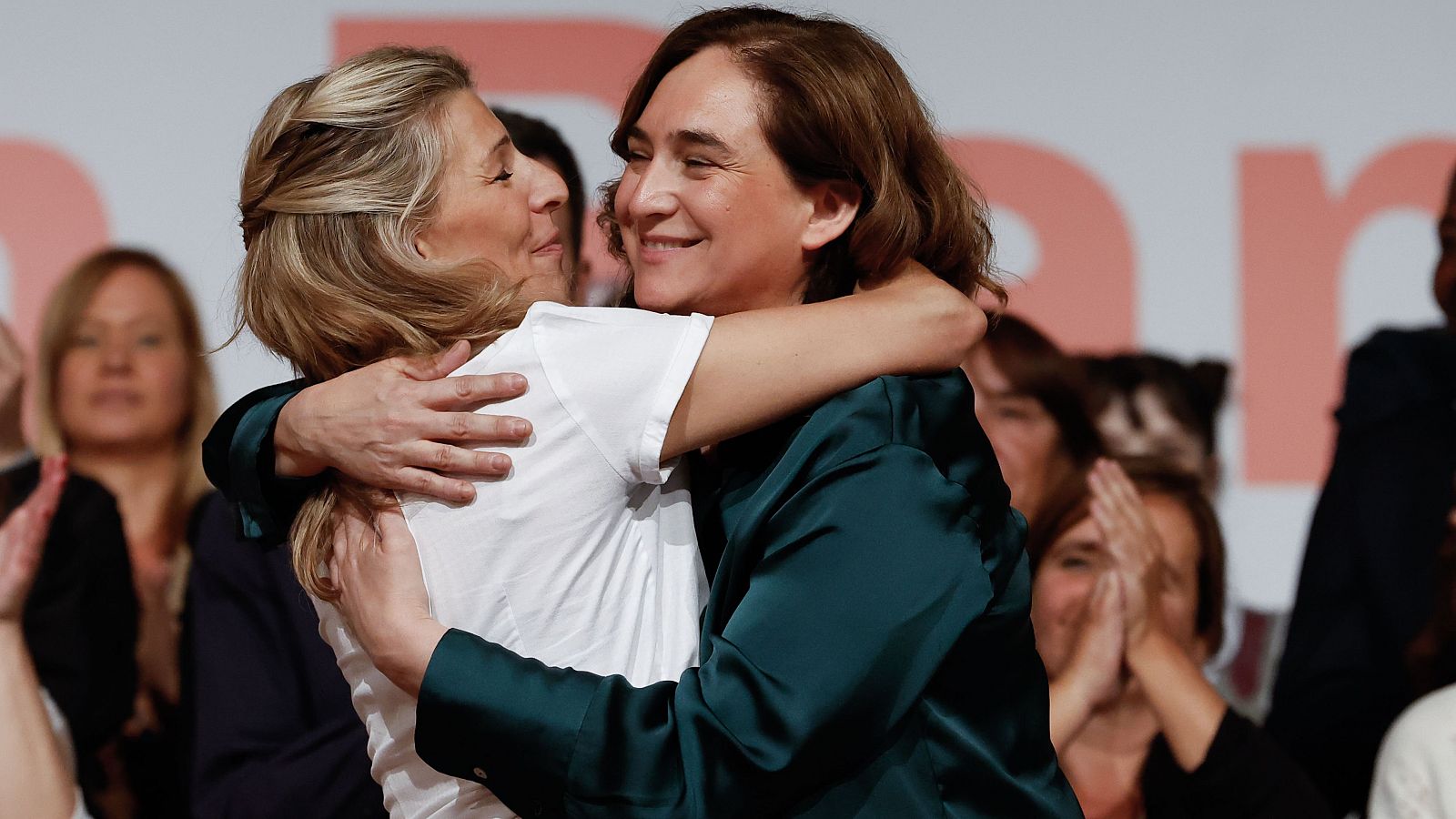 La vicepresidenta segunda del Gobierno y líder de Sumar, Yolanda Díaz (i) y la alcaldesa de Barcelona y candidata de los comunes a la reelección, Ada Colau (d), se dan un abrazo durante el acto