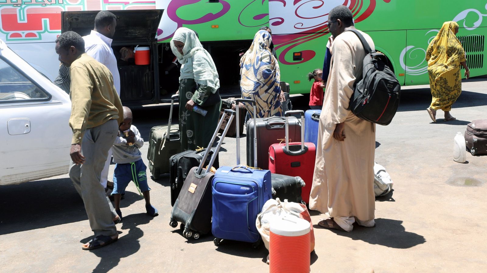 Varias personas que han huido de Sudán llegan a la estación de autobuses de Wadi Karkar, en Egipto