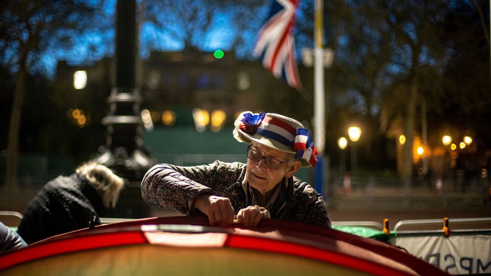 Un hombre prepara su tienda de campaña mientras espera el desfile de la coronación en la avenida de The Mall, en Londres