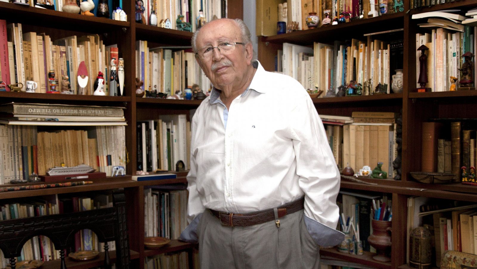El poeta granadino Rafael Guillén posa en un cuarto con estanterias llenas de libro (2014)