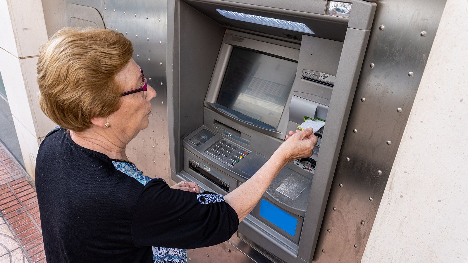 Una pensionista mete la tarjeta de crédito en un cajero automático