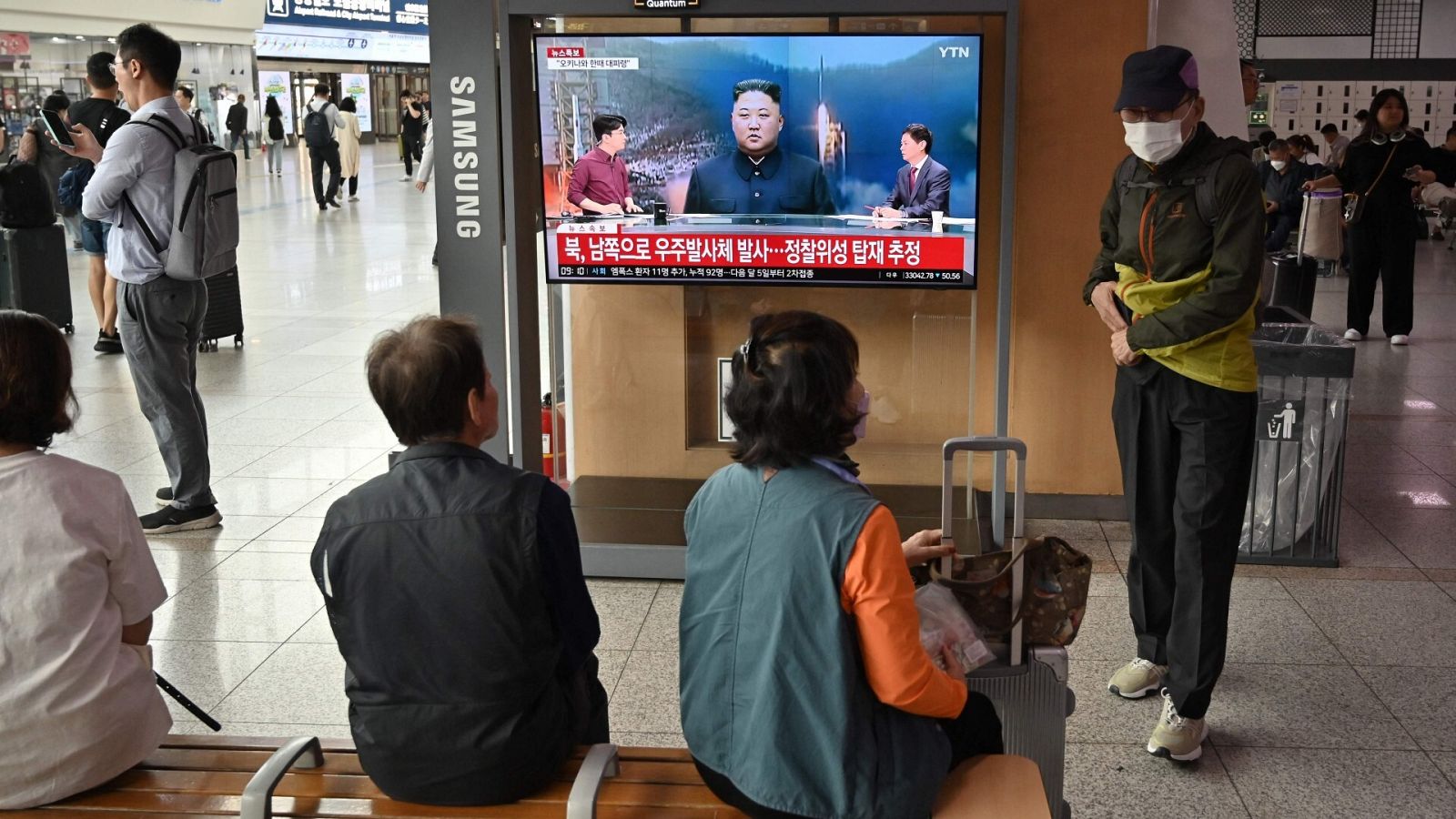 Varias personas miran una pantalla que muestra imágenes del líder norcoreano, Kim Jong Un, en la estación de tren de Seúl