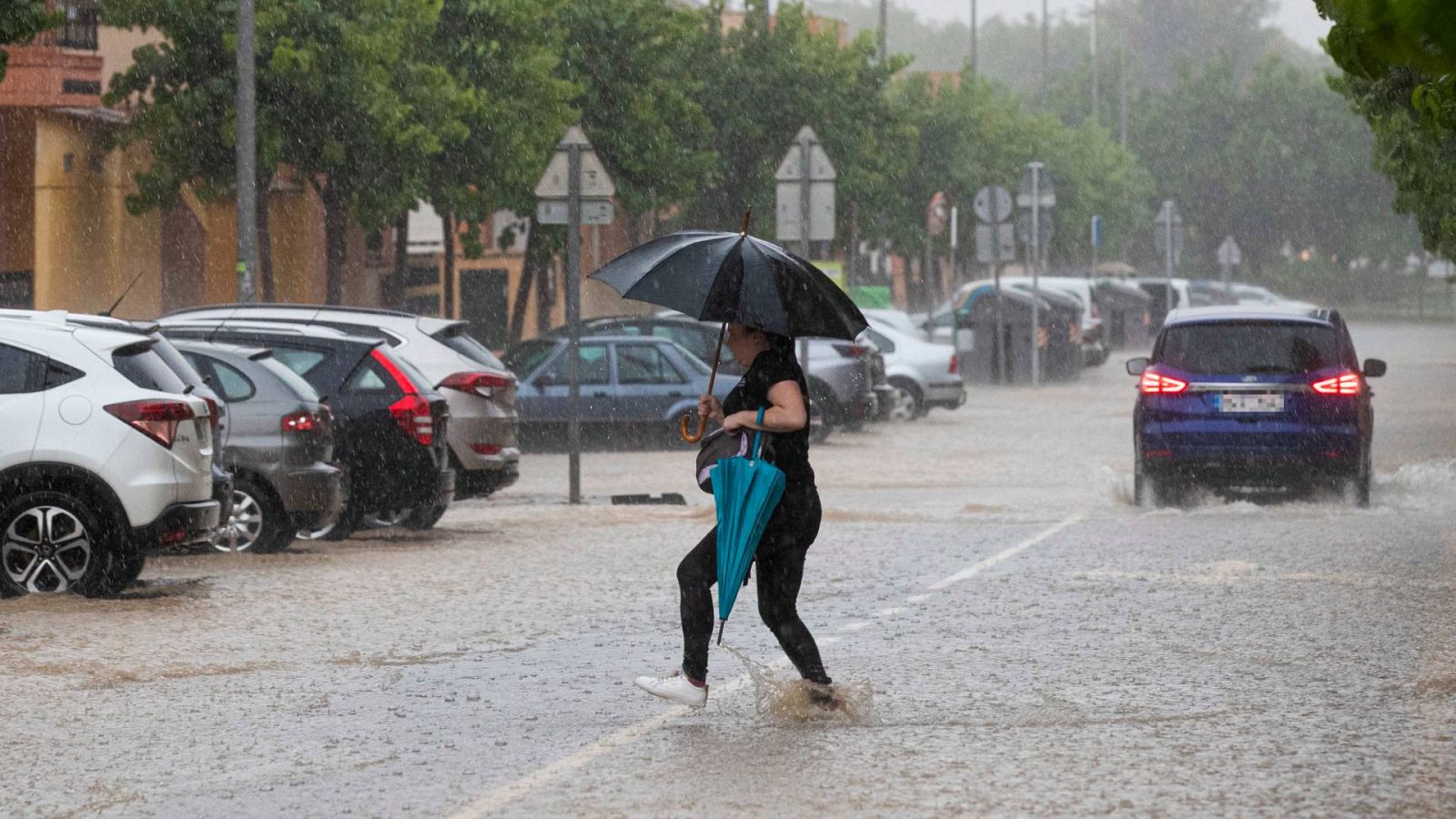 Una mujer cruza una calle inundada tras la tormenta de granizo y agua este miércoles en la pedanía de La Alberca (Murcia)
