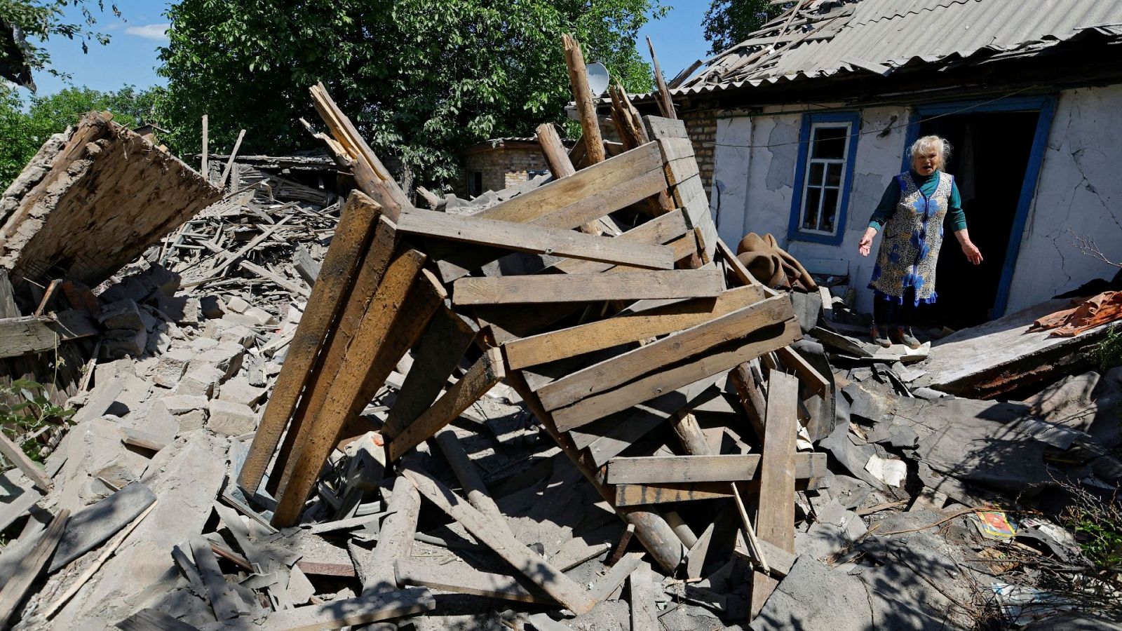 Una mujer mira las ruinas de su garaje que ha quedado destruido tras el impacto de una bomba.