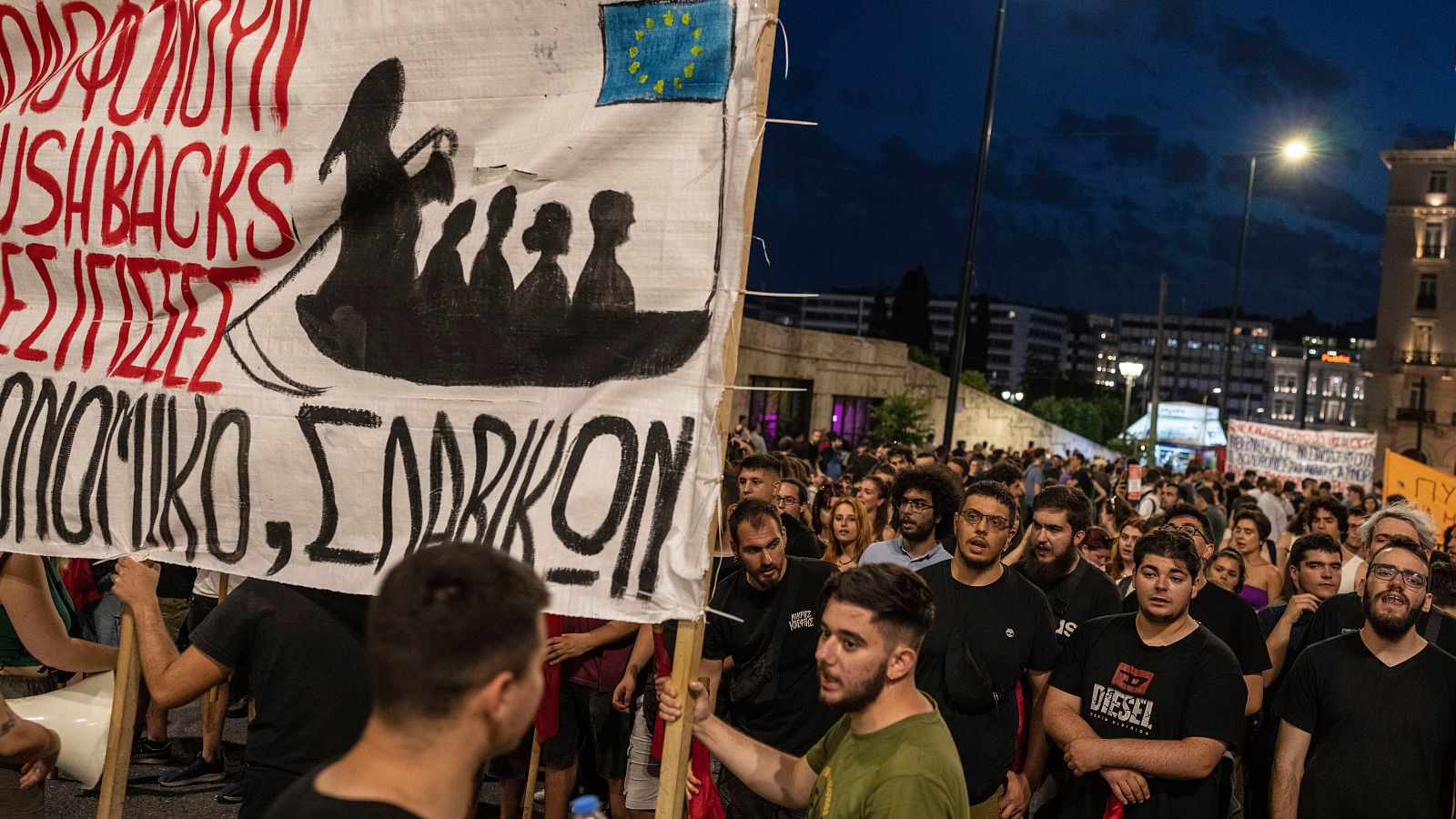 Manifestantes sostienen una pancarta durante una manifestación tras el naufragio mortal de un barco pesquero con 700 migrantes frente a Grecia