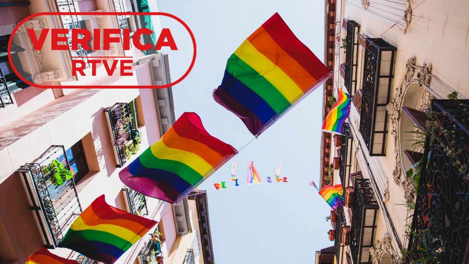 Imagen de recurso de una calle con varias banderas del colectivo LGTBI, con el sello VerificaRTVE en rojo