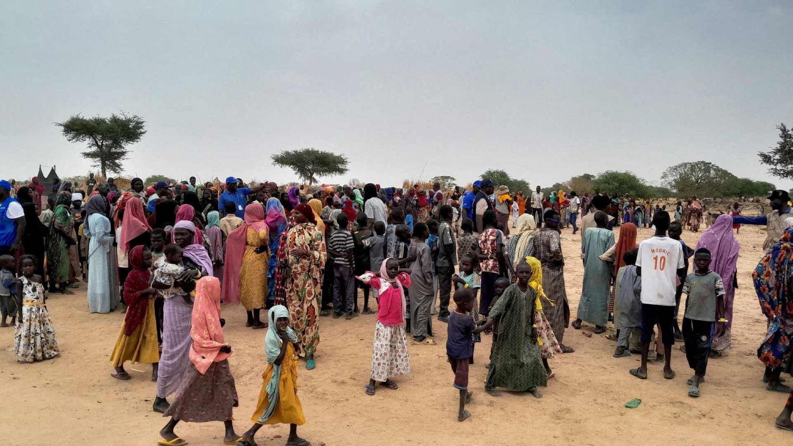 La población sudanesa huye de la violencia en su país y esperan a ser registrados en el campamento cercano a la frontera entre Sudán y Chad.