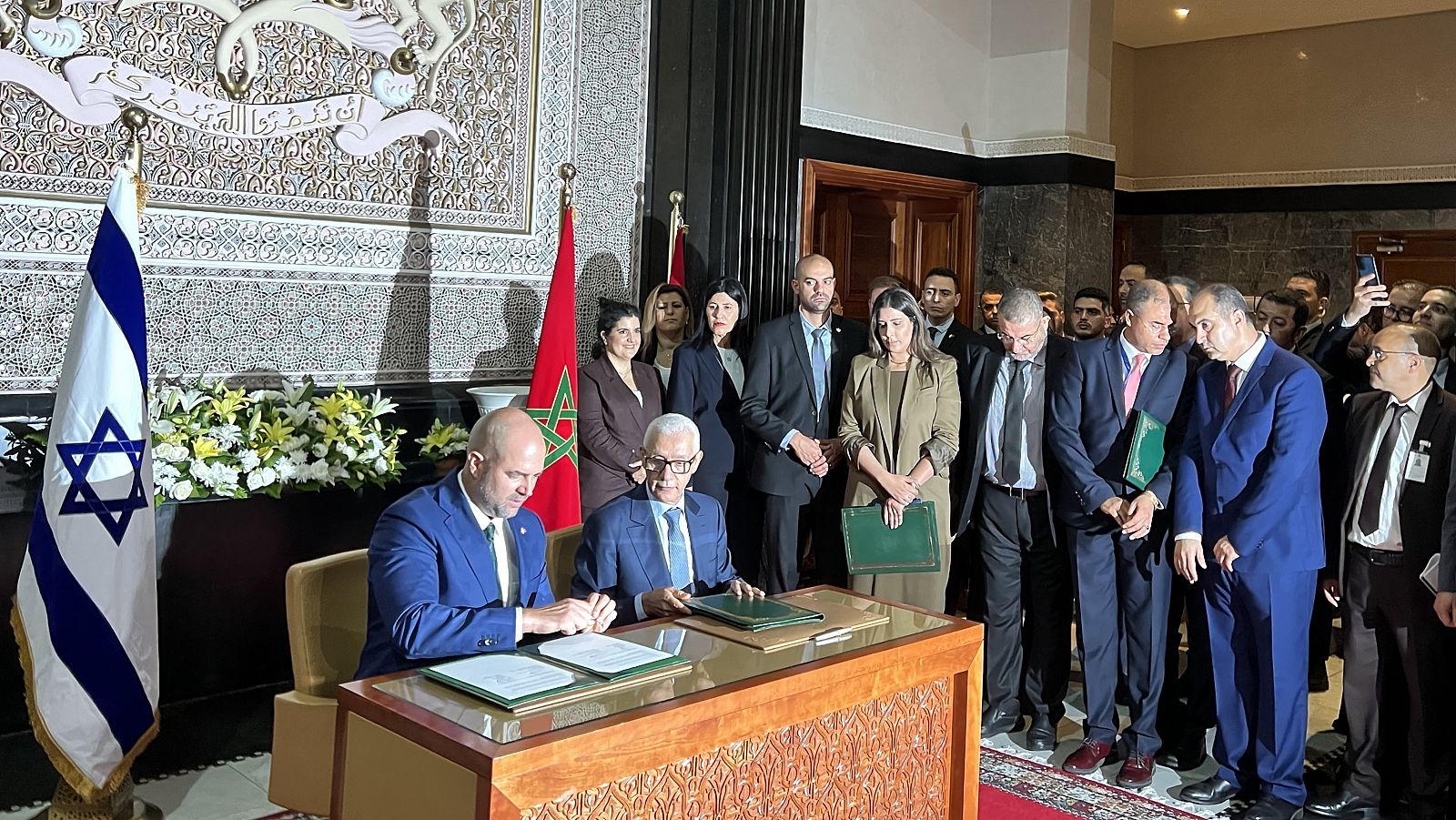 El presidente de la Knéset (Parlamento) israelí, Amir Ohana (i), y su homólogo, Rachid Talbi Alami (2i), firman documentos en la sede del Parlamento marroquí