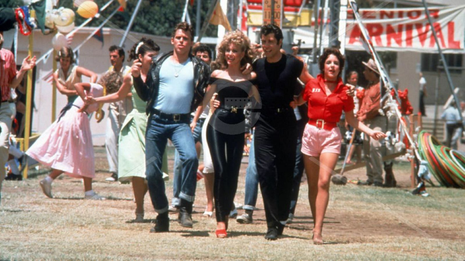 Sandy, Danny, Kenickie y Rizzo en "Grease", abrazados caminando