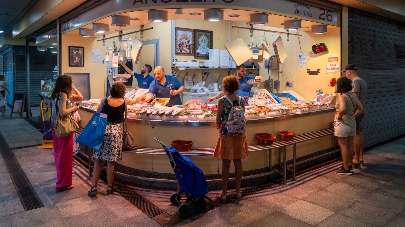 Varias personas compran en un mercado de Sevilla