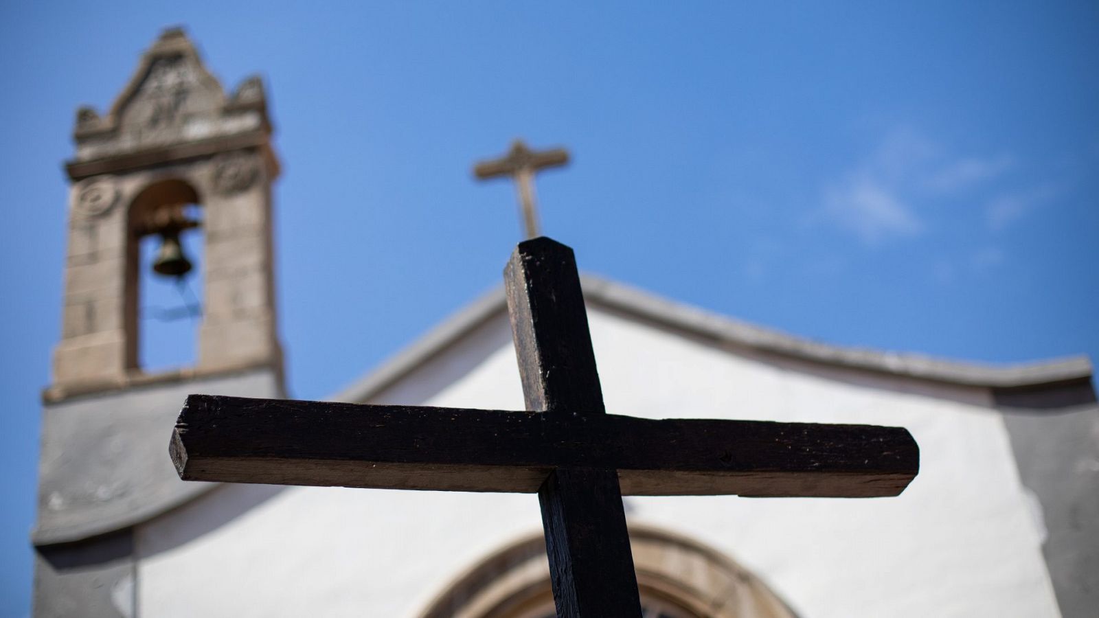 La fachada de una iglesia y una cruz