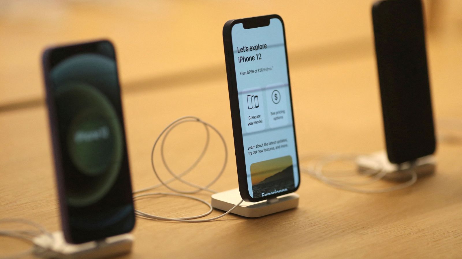 Imagen de archivo de tres iPhone 12 expuestos en una tienda de Apple.