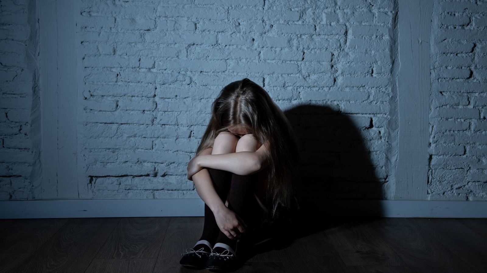 Agresiones sexuales infancia: Una niña se acurruca, abrazando sus piernas, en imagen de archivo