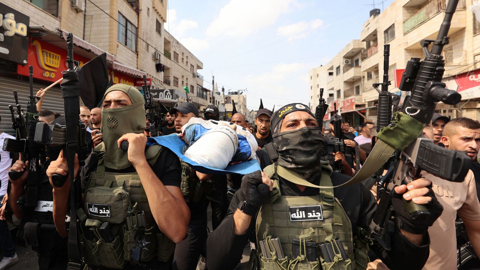 Militantes palestinos cargan el cuerpo de un joven muerto en los enfrentamientos con fuerzas israelíes