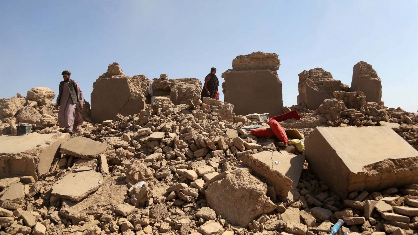 Varias personas buscan sus pertenencias entre los escombros en Herat, Afganistán