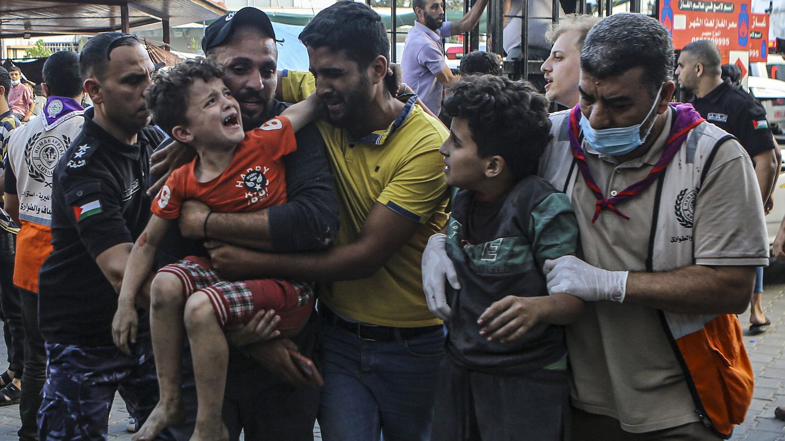 Ciudadanos palestinos llevan a un niño llorando a un hospital de Gaza
