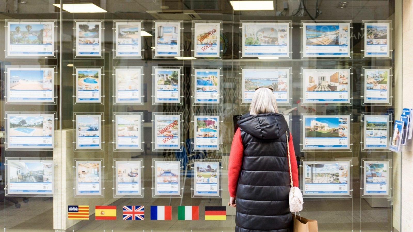 Una mujer observa la oferta de vivienda frente al escaparate de una inmobiliaria en Mahón, Menorca, a principios de 2023.