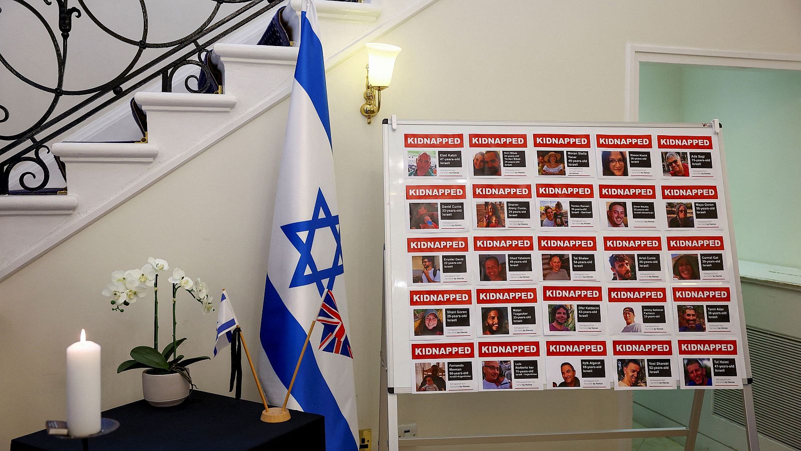Una bandera de Israel y carteles con las imágenes de algunos de los secuestrados