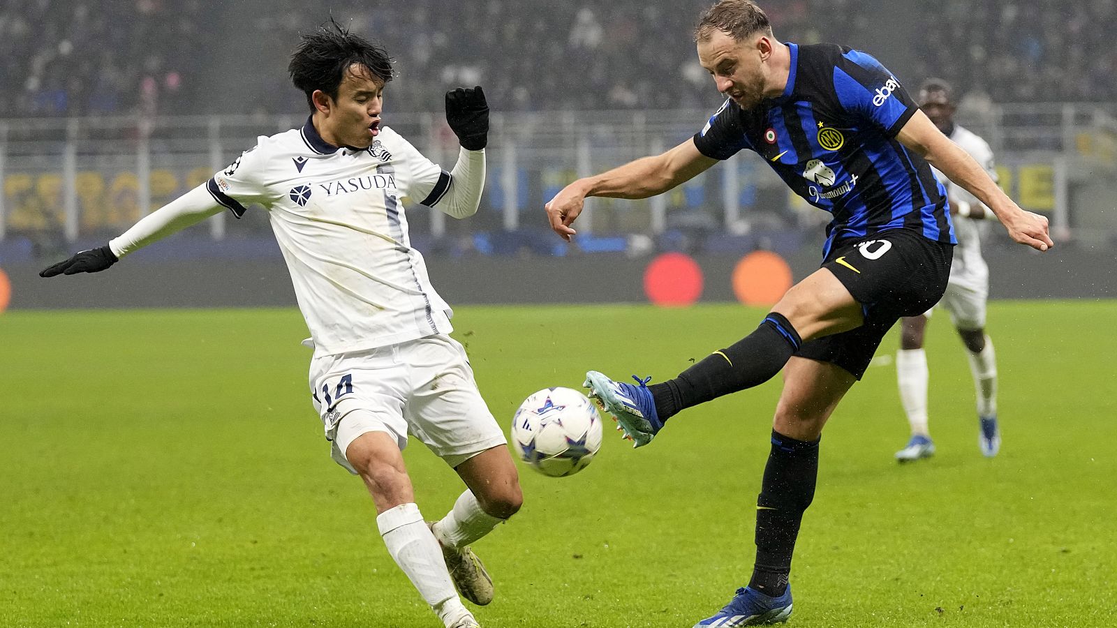 Take Kubo defiende a Carlos Augusto en un lance del Inter - Real Sociedad