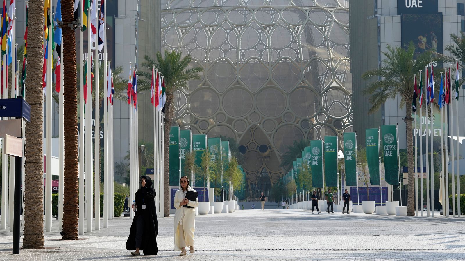 La gente pasea en las inmediaciones de la Cumbre del Clima de Dubai el último día del evento.