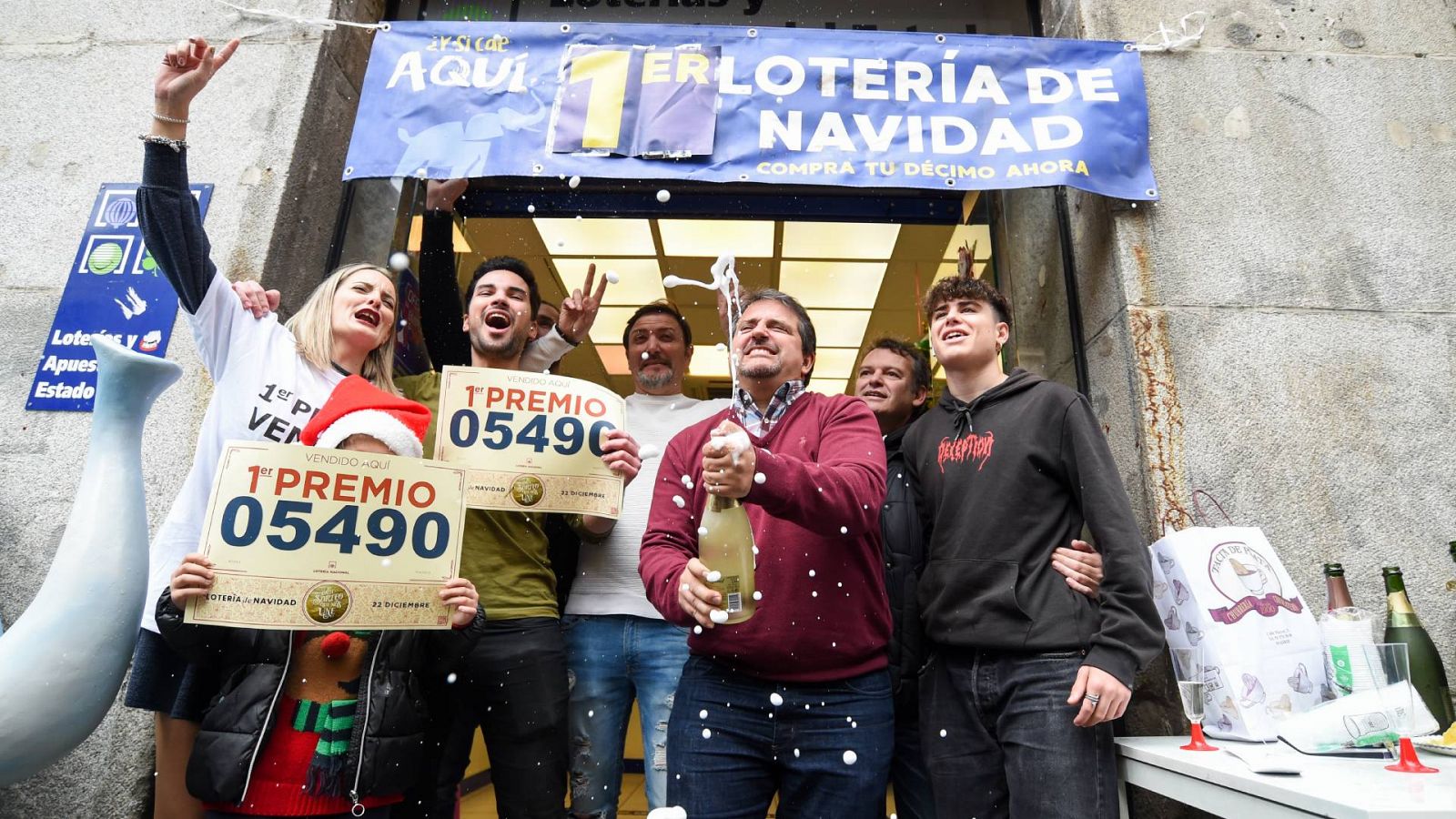 Varias personas celebran el primer premio de la Lotería de Navidad de 2022 que cayó en el 05.490