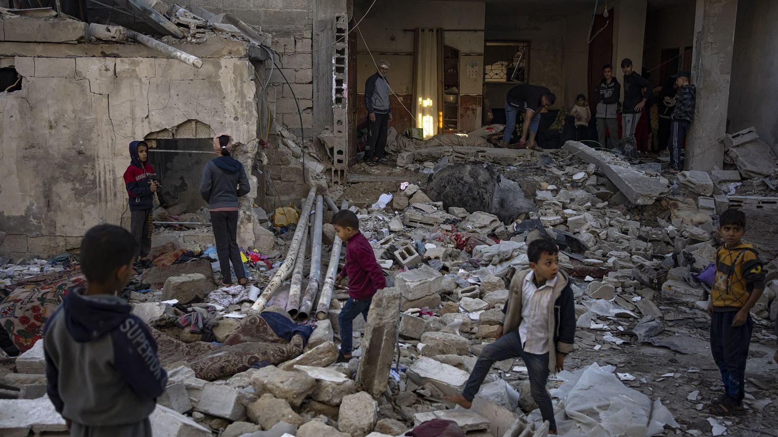 Niños gazatíes juegan sobre los escombros de su antigua casa tras un bombardeo israelí