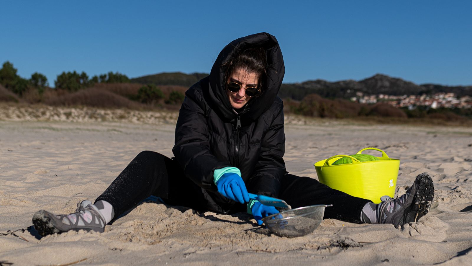 Una voluntaria recoge 'pellets' de la arena en una playa de A Coruña.