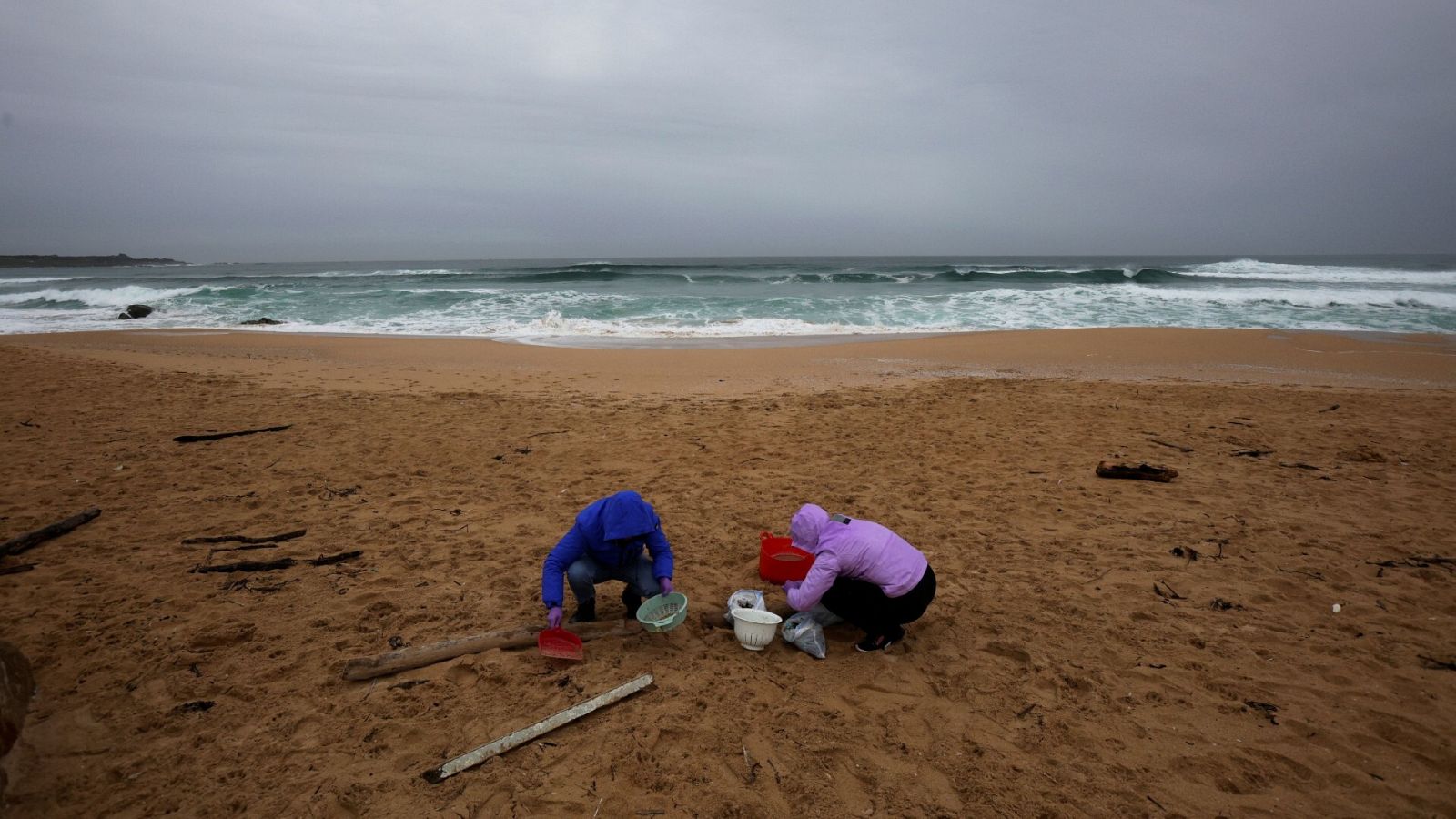 Voluntarios limpian la playa do Vilar, en Ribeira, tras el vertido de pélets
