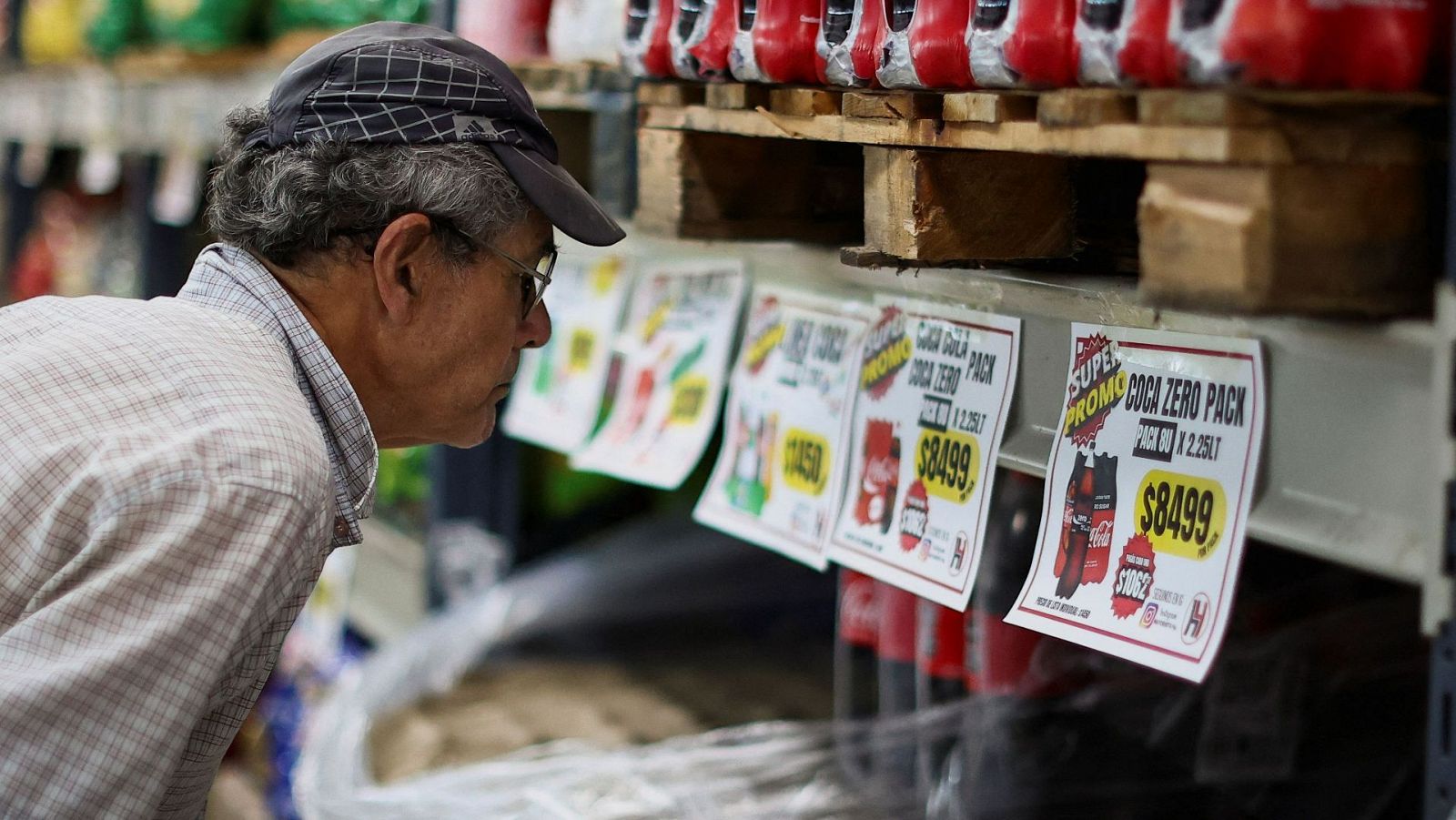 Un hombre comprueba los precios de los refrescos en un supermercado