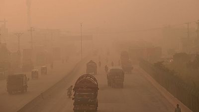 Viajeros circulan por una carretera sumida en niebla y humo en Lahore, Pakistán, en octubre de 2021.