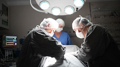 Varios doctores intervienen a un paciente en quirófano.