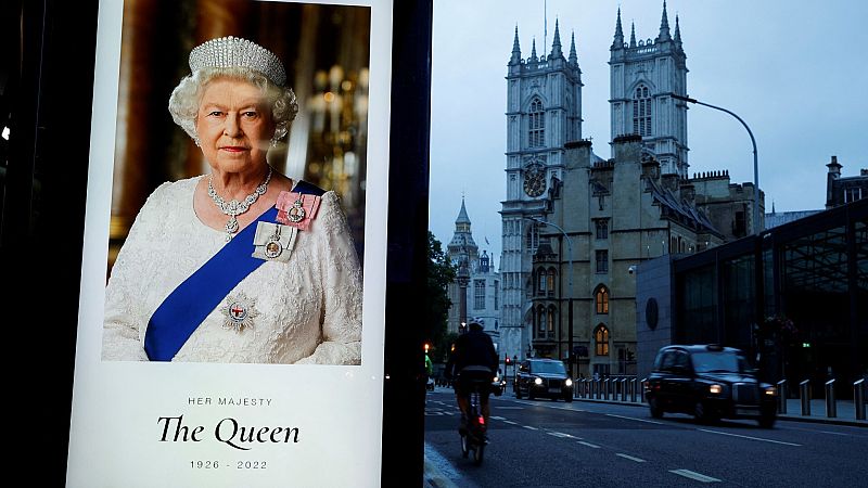 Un cartel recuerda a la difunta reina Isabel II, con la Abadía de Westminster de fondo.