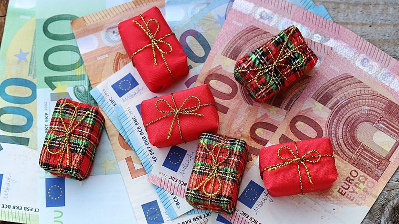 Lotería de Navidad: unos regalos de Navidad sobre una serie de billetes Lotería de Navidad: unos regalos de Navidad sobre una serie de billetes