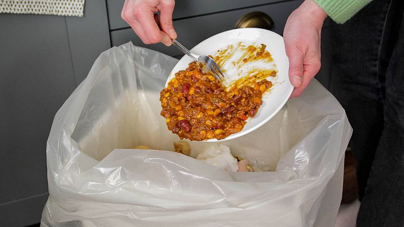 Una persona tira un plato de comida a la basura