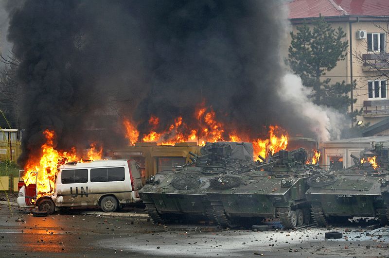 French NATO peacekeeping vehicles burn during clashes with Serb protesters in the ethnically divided city of Mitrovica